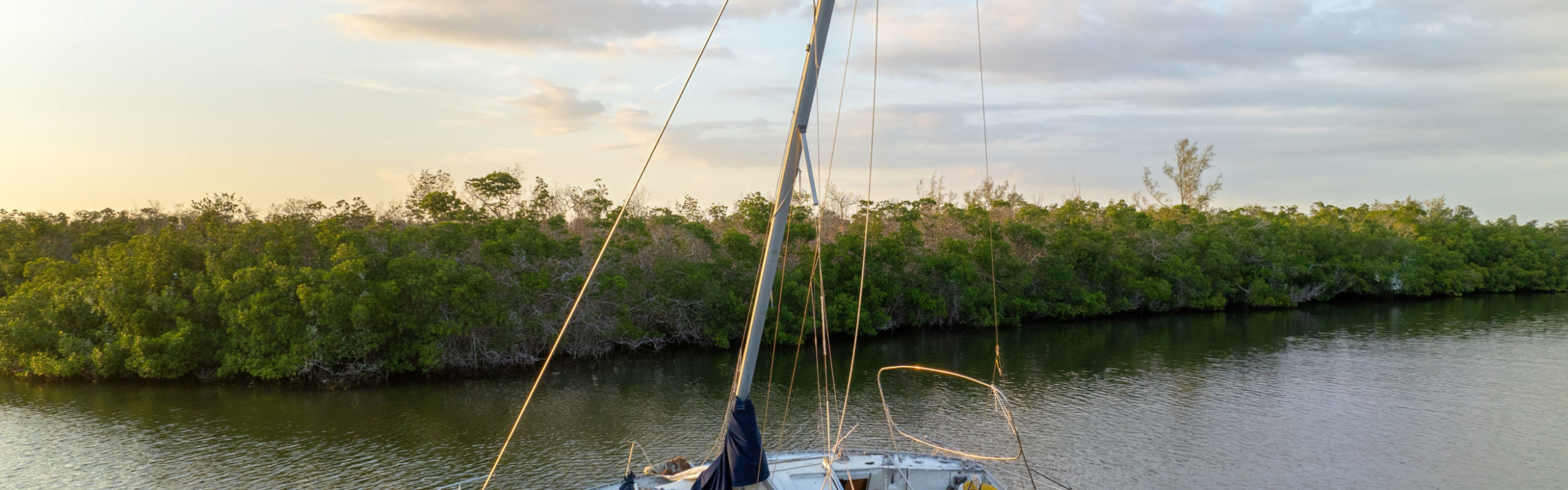 Capsized sunken sailing boat left forsaken on shallow bay waters after hurricane Ian in Manasota, Florida