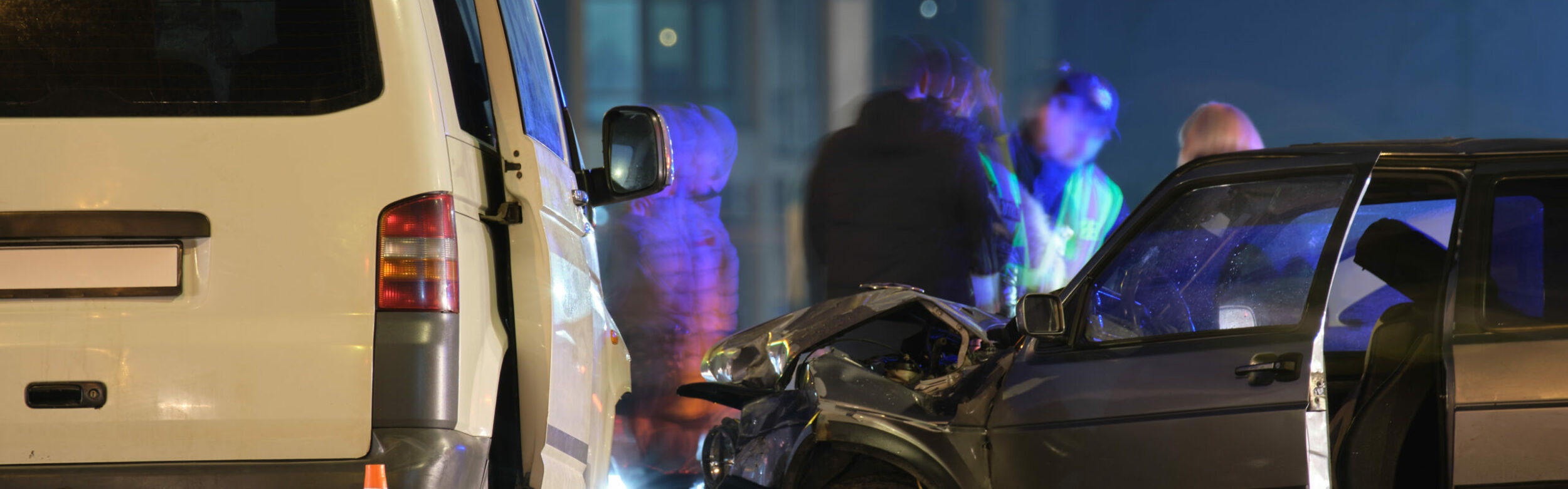 Cars crashed heavily in road accident after collision and silhouette of people on city street at night. Road safety and insurance concept